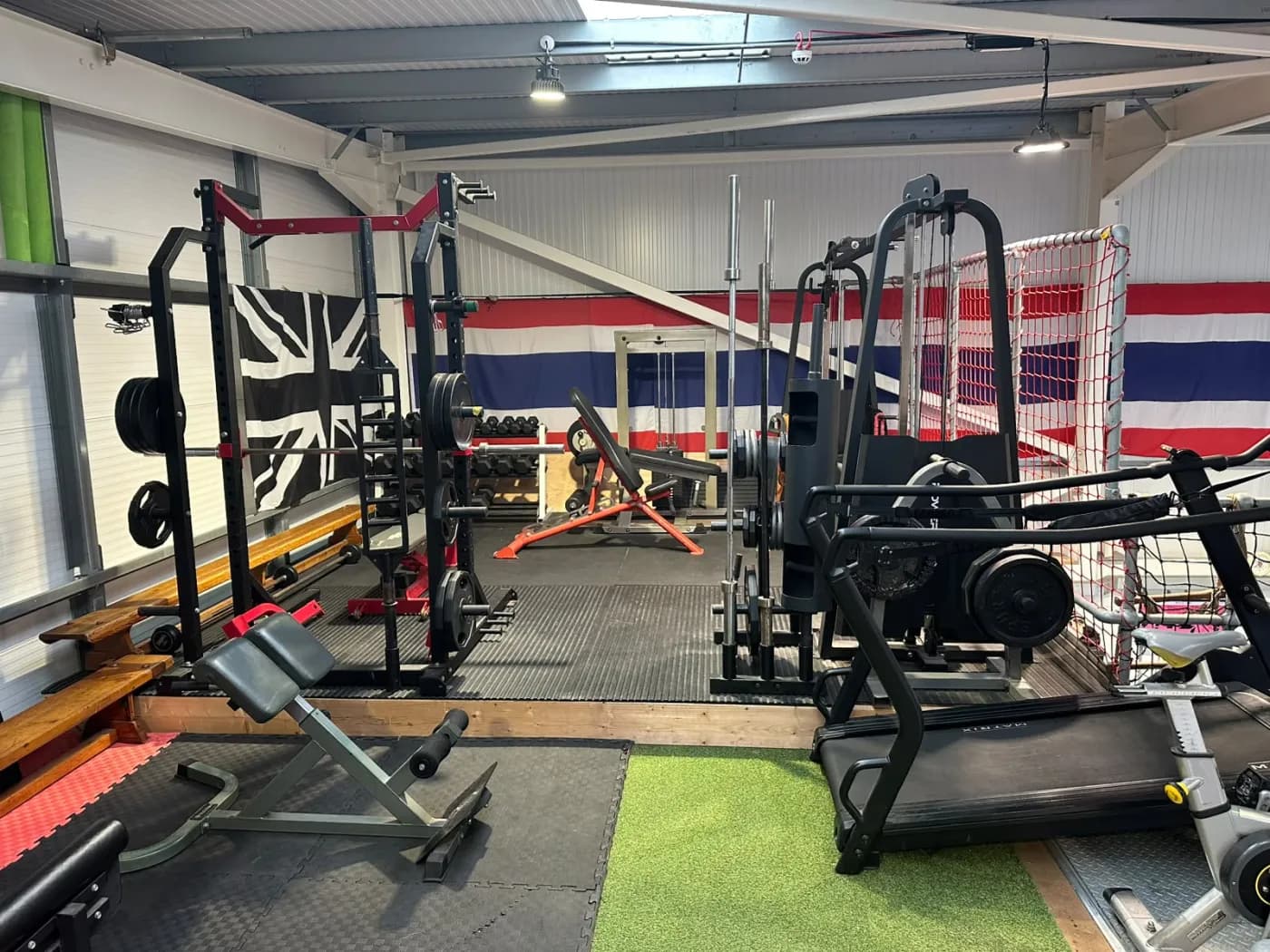 Strength and conditioning area with racks, weights and cardio kit